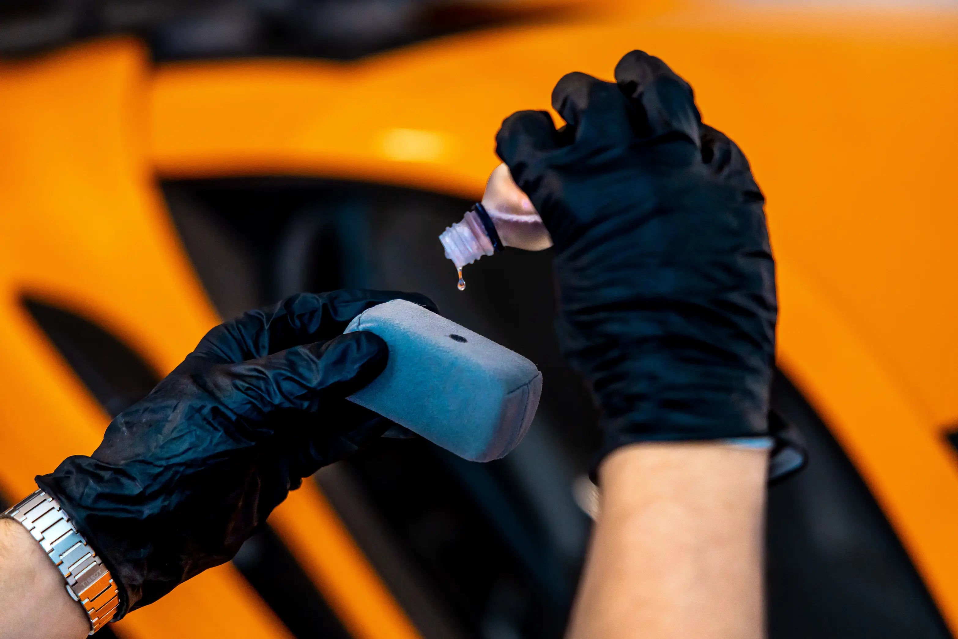 Person pouring ceramic coating on the applicator sponge